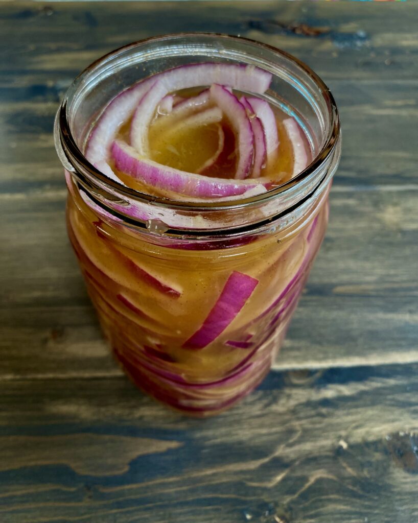 Red onion and brine filling the mason jar.