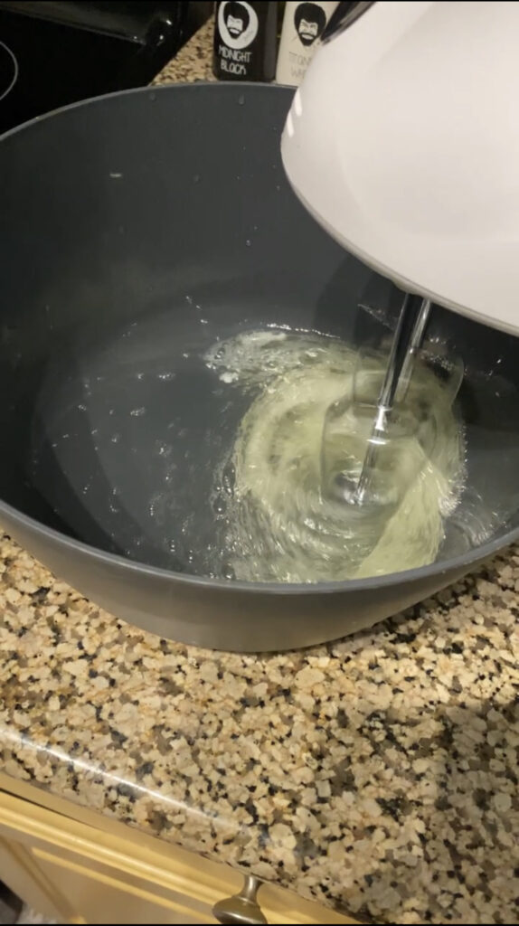 Using a mixer to start beating egg whites.