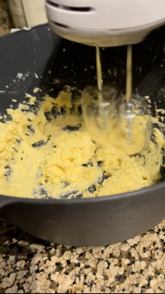 Egg yolks being mixed into butter mixture.