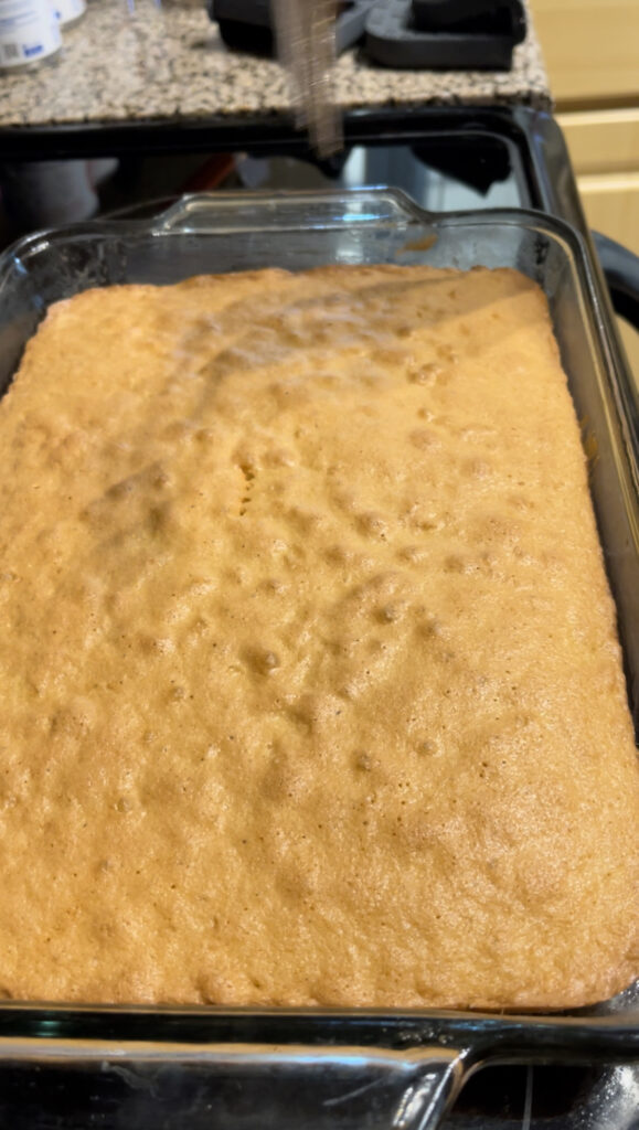 Cake pulled out from the oven. Slight golden brown with the cake pulling from the sides.