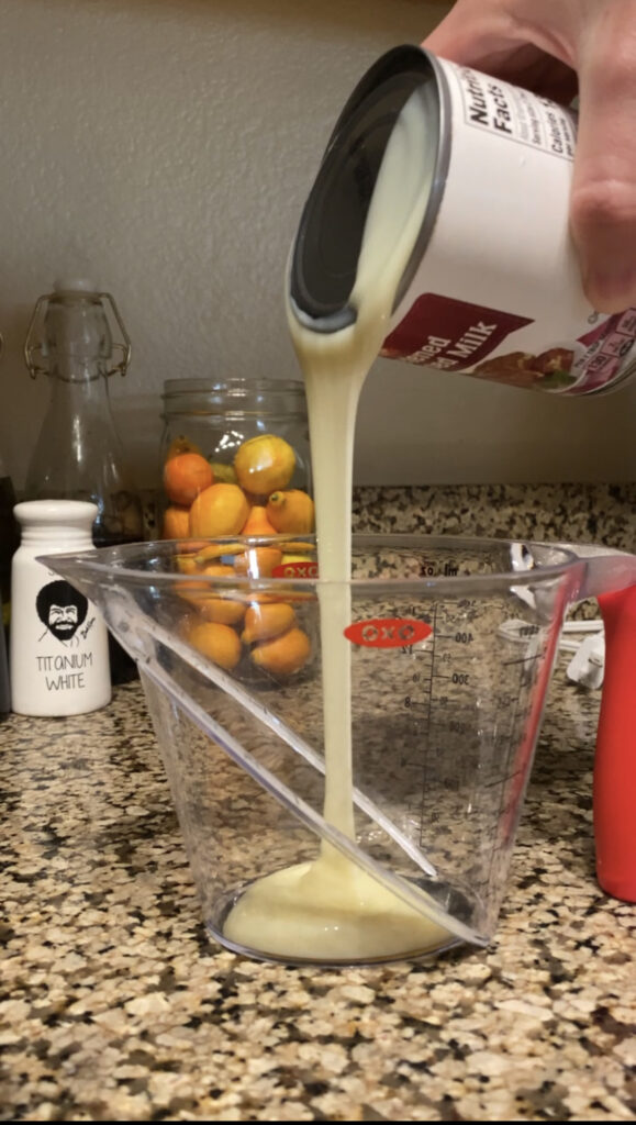 Pouring sweetened condensed milk into measuring cup.