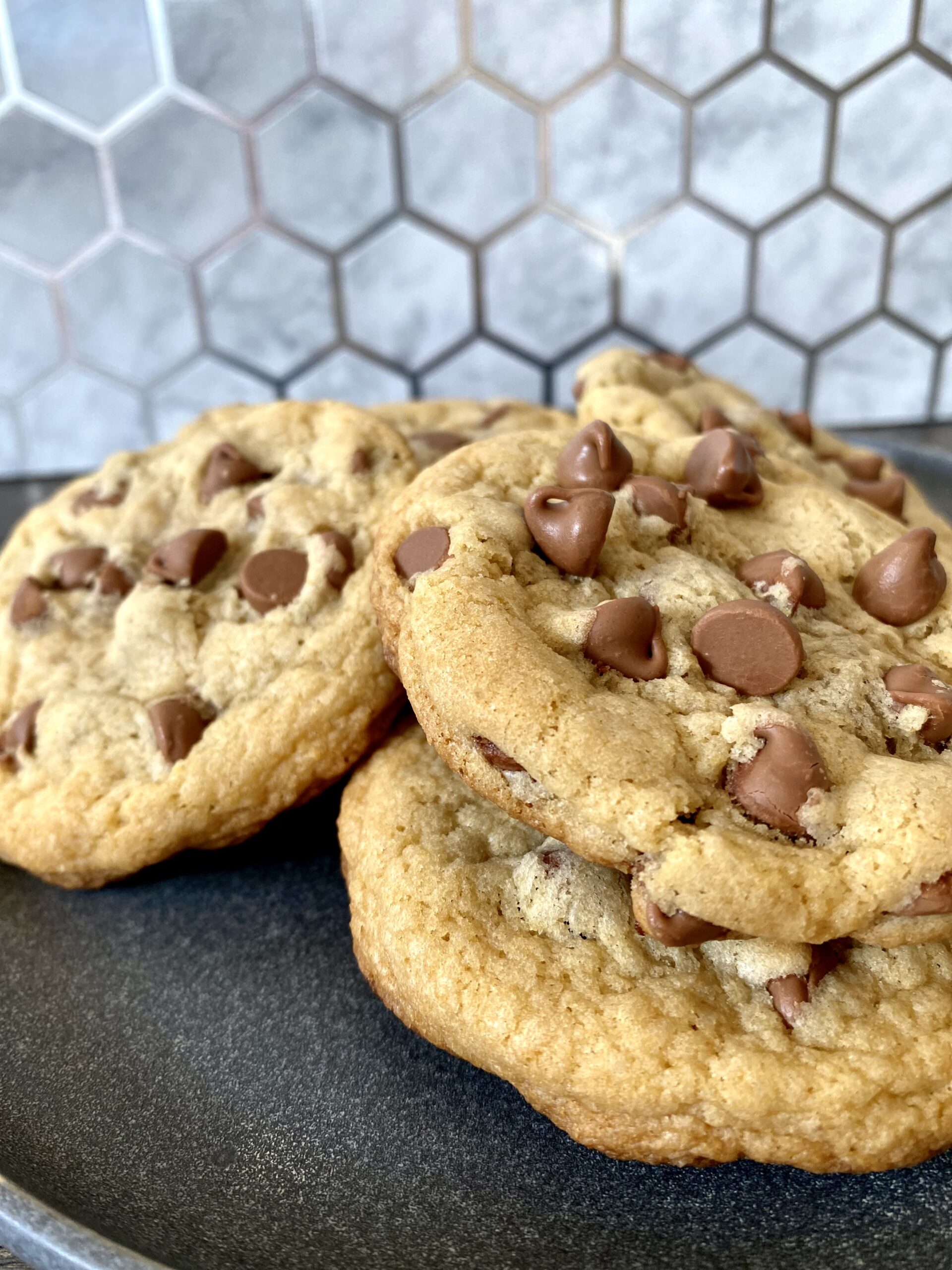 Upclose shot of three chocolate chip cookies fresh from the oven.