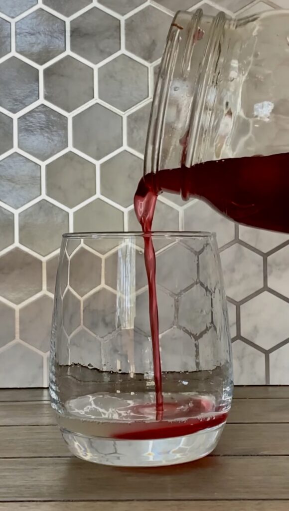 Cherry syrup being poured into a cup.