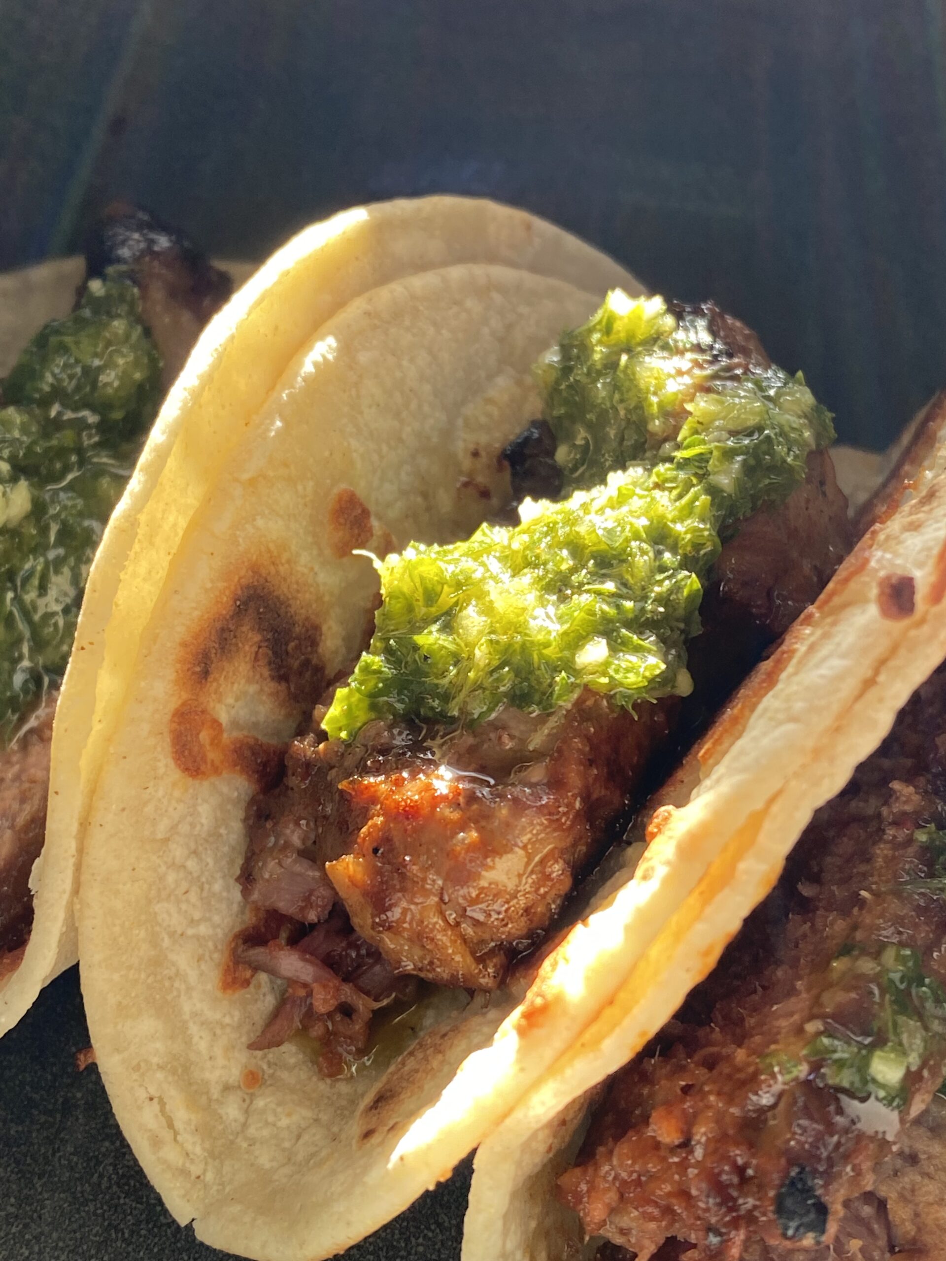 Chimichurri sauce glowing on steak tacos.