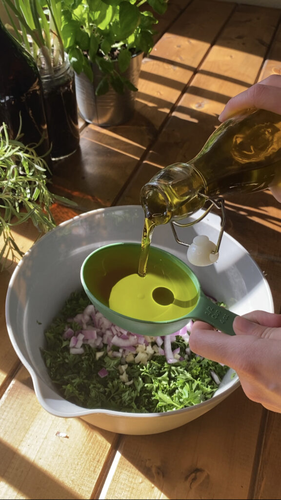 Olive oil being poured into a measuring cup.