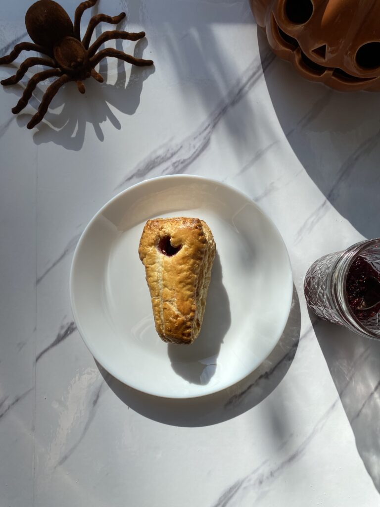 Raspberry Cheese Danish on a plate with a spider near by