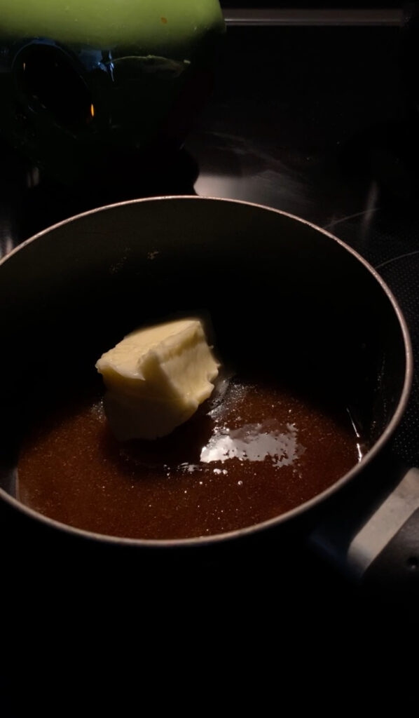 Adding butter to melted sugar.