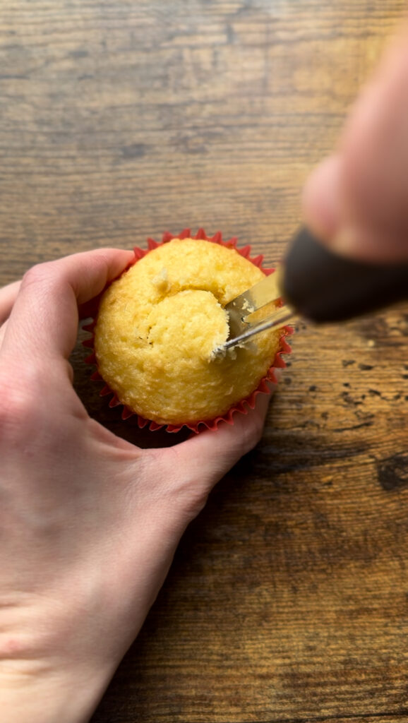 Cutting out the center of a cupcake.