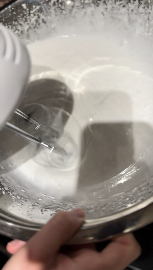 Whipping Hi hat frosting over a double boiler.