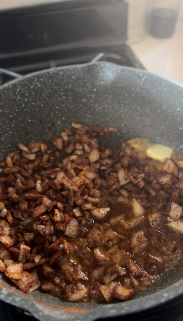 diced onion in frying pan with butter and paprika for chicken paprikash with added butter and water