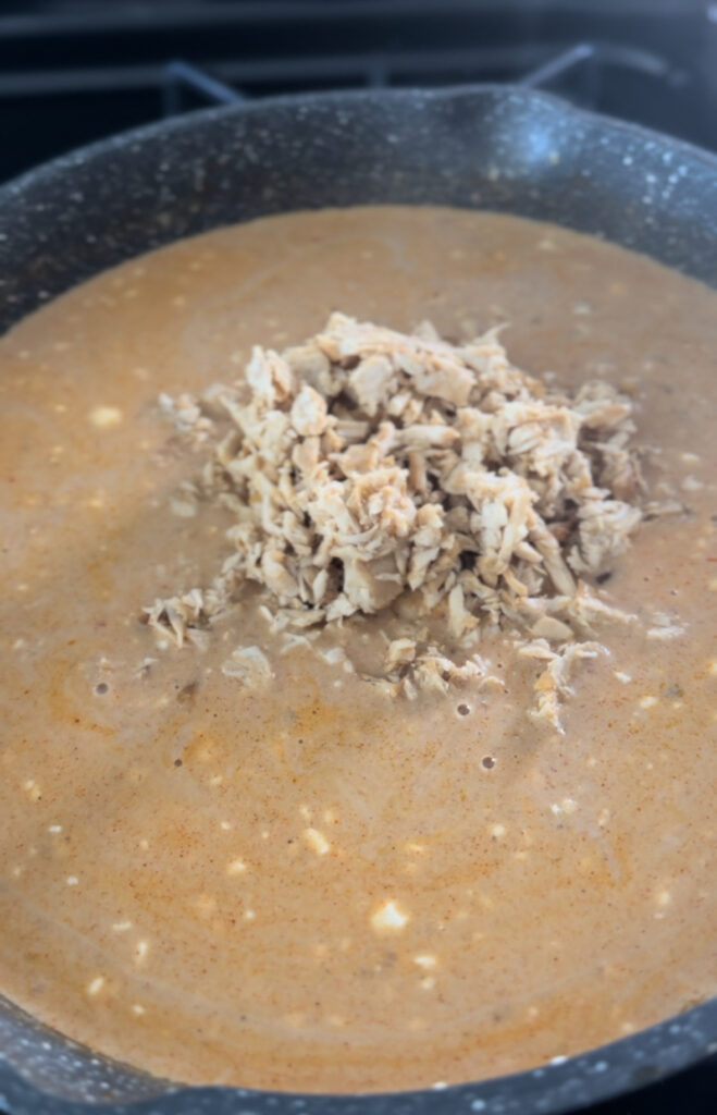 adding shredded chicken to broth