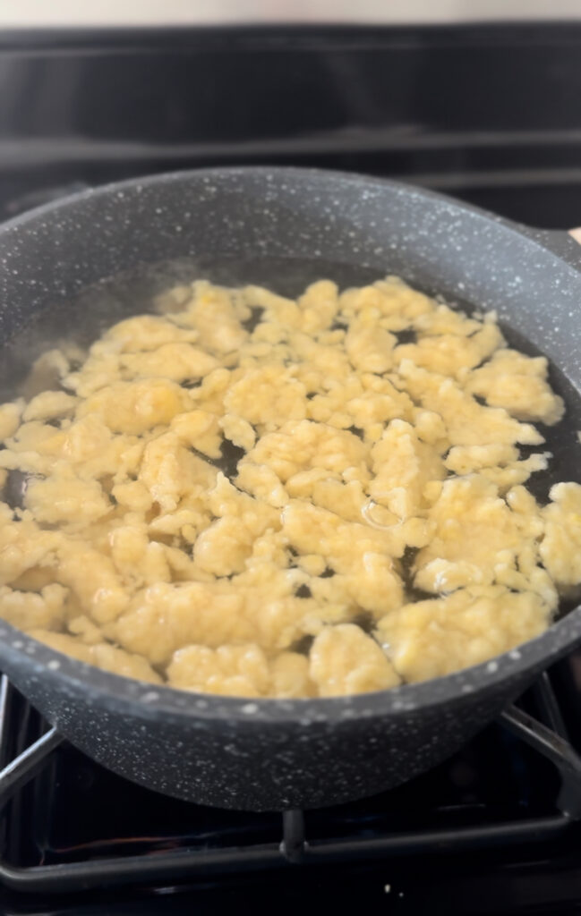 dumplings floating on the top of boiling water