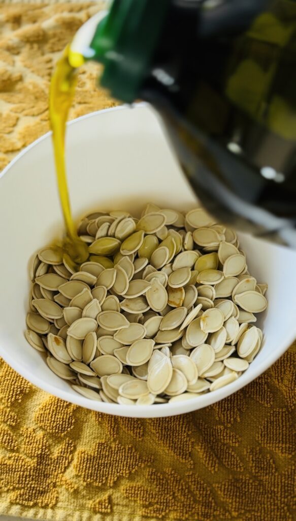 Pouring olive oil over pumpkin seeds