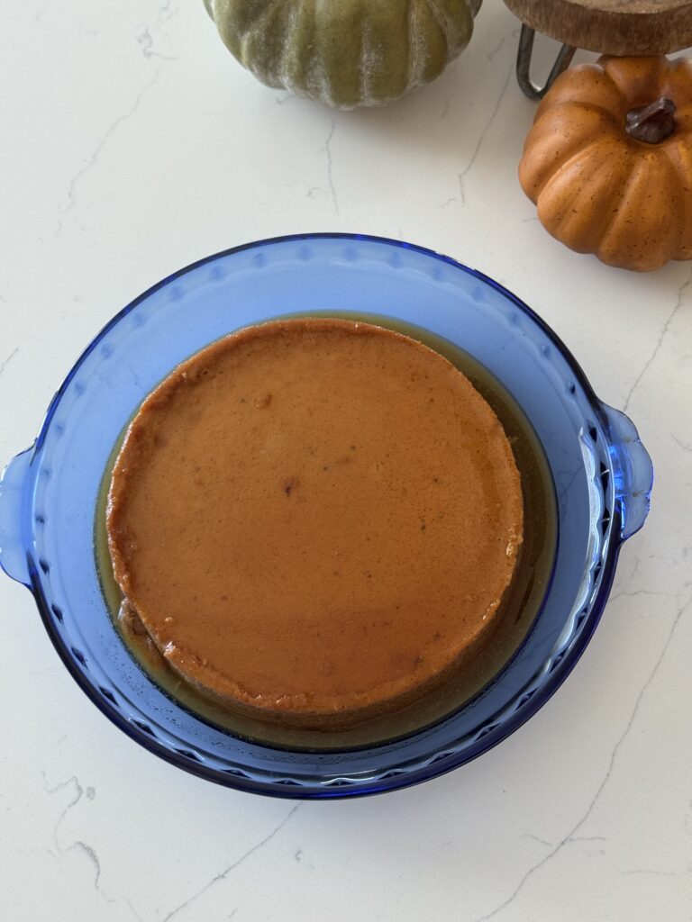 Creamy pumpkin flan topped with golden caramel sauce on a white plate — the perfect Mexican American Thanksgiving dessert