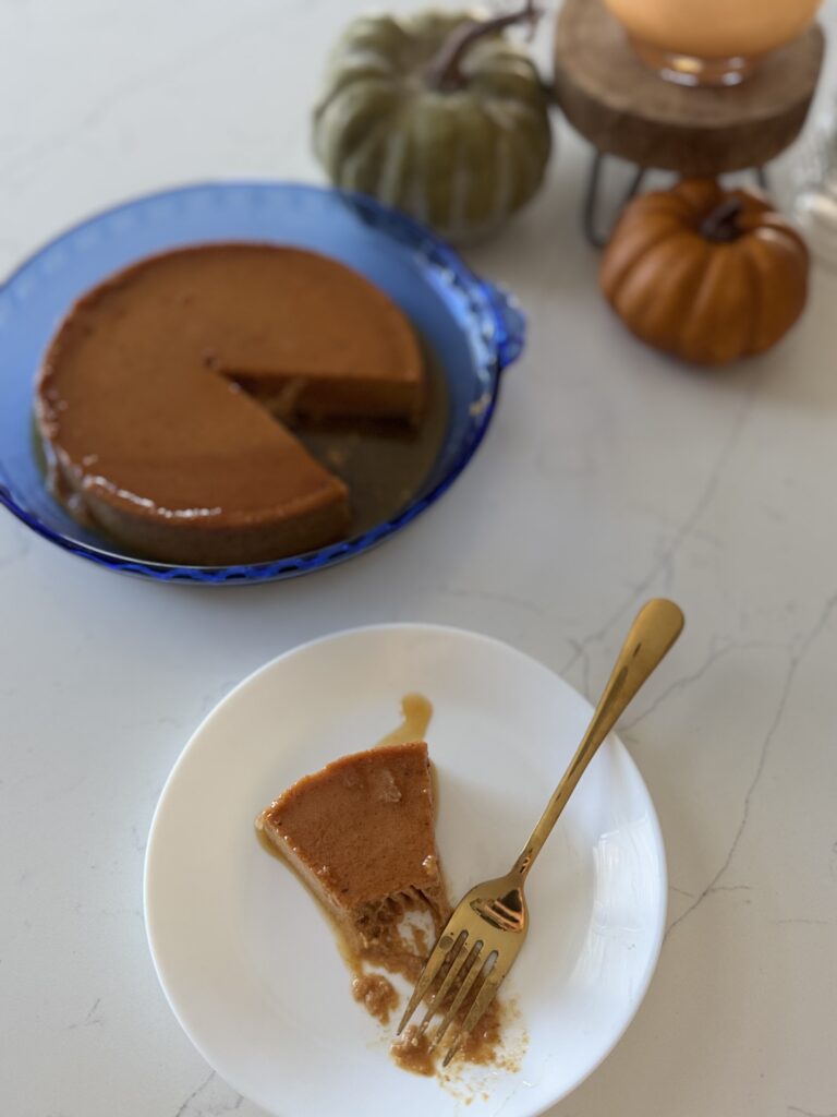 A slice of pumpkin flan with a bit taken out of it
