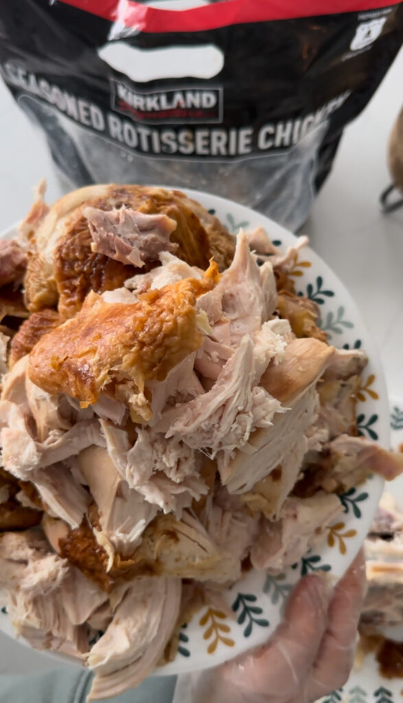 A costco rotisserie chicken shredded and ready to be used in a meal.