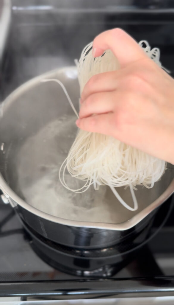 dropping pho noodles in boiling water