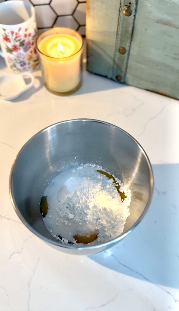 three egg yolks, cornstarch and sugar in a bowl.