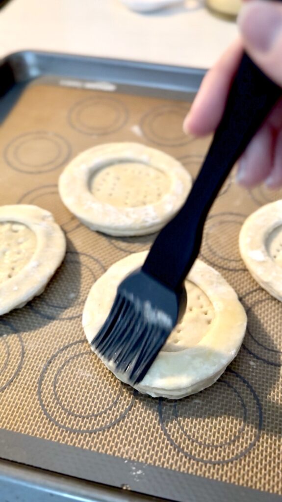 using a brush to brush on an egg wash