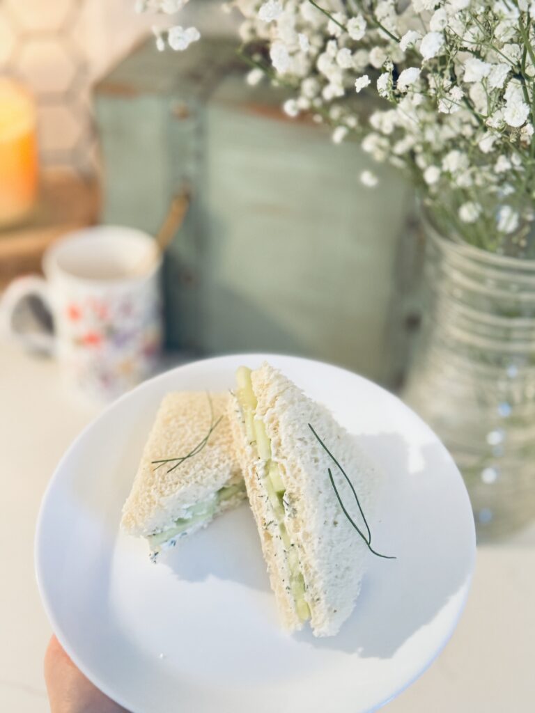 cucumber tea sandwiches served on a plate neatly with a cup of tea