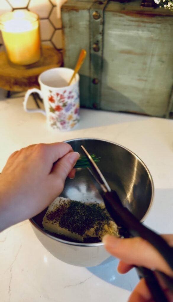 cutting chives over cream cheese mixture