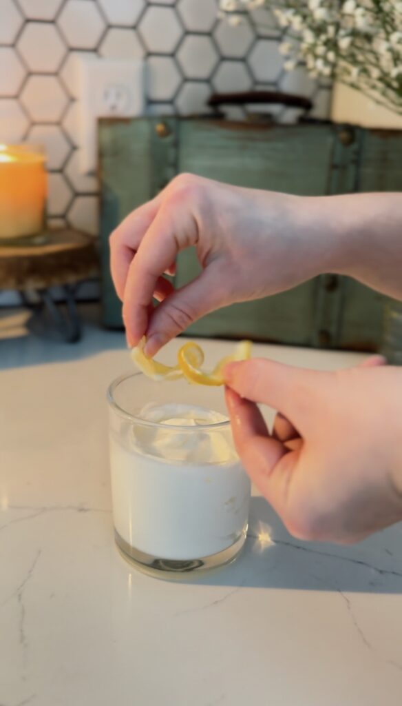 placing a lemon curl on top of the lemon syllabub