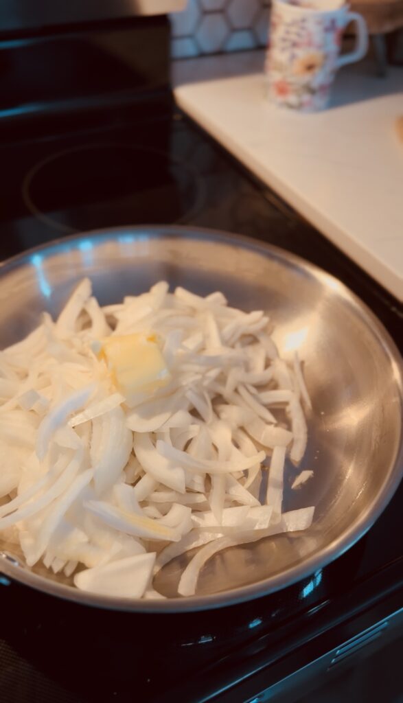 sliced onions and butter in a frying pan