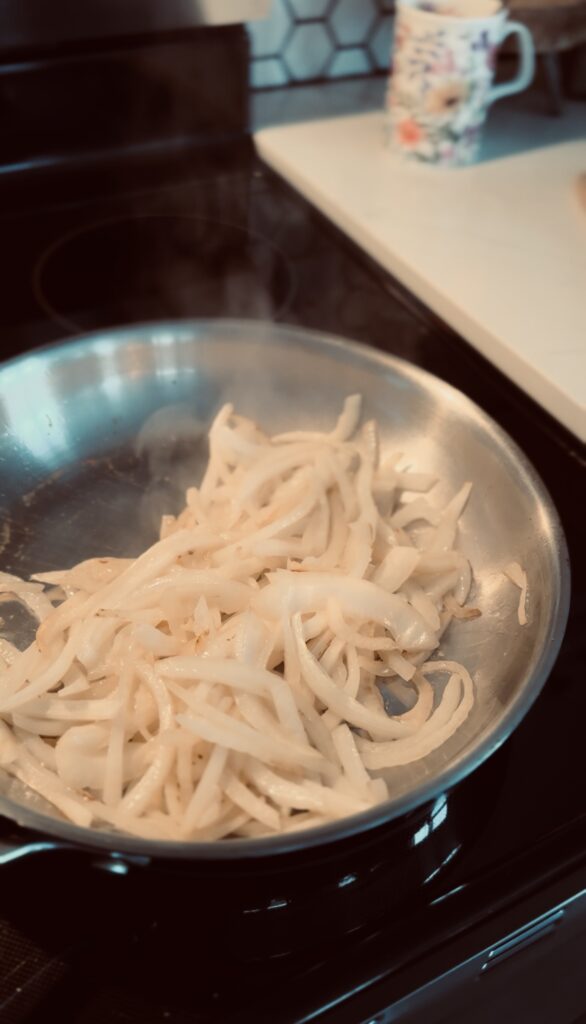 frying sliced onions in a frying pan.