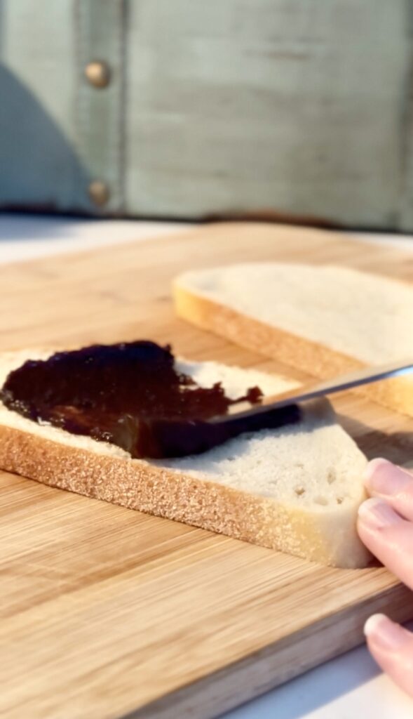 spreading fig jam on a slice of bread