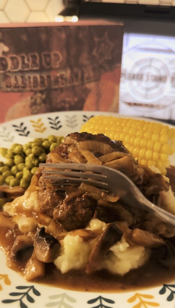 A fork cutting through the salisbury steak