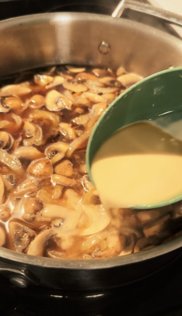 slowly pouring cornstarch slurry into the pan.