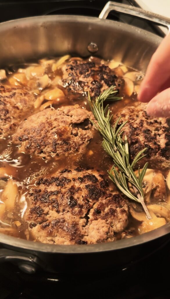 Adding a sprig of Rosemary to the pan