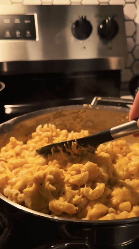 Mixing the noodles into the mac anchovies cheese