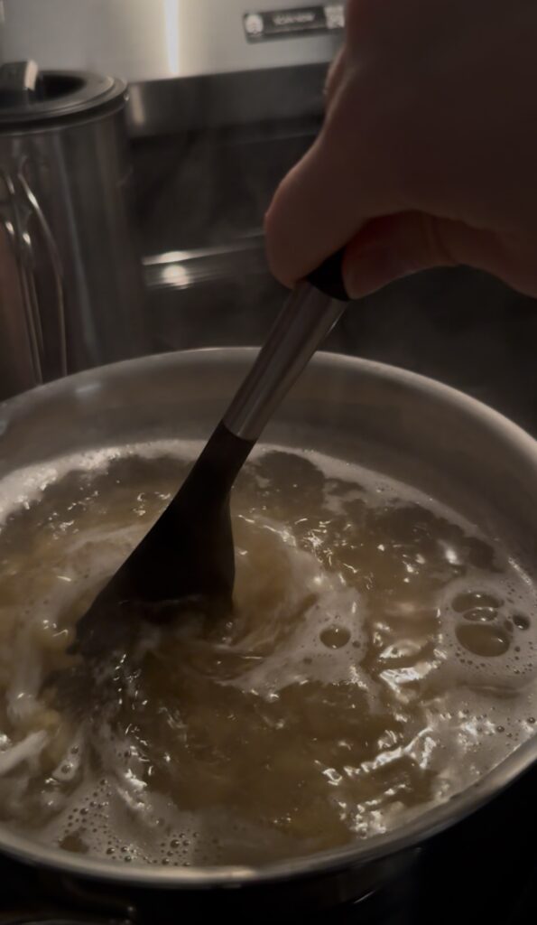 Stirring noodles in a pot.