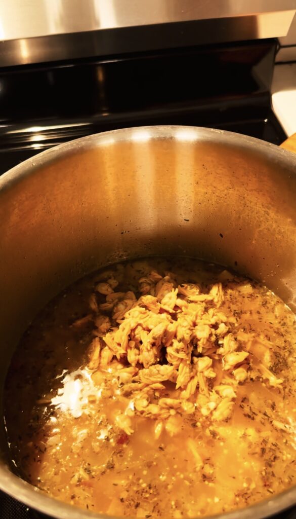 Clams being added to the clam chowder soup in a pot