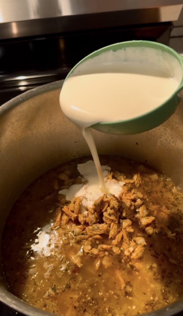 pouring cream into the soup clam chowder